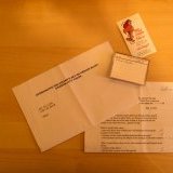 Package content (DV tape, business card, GPS coordinates)